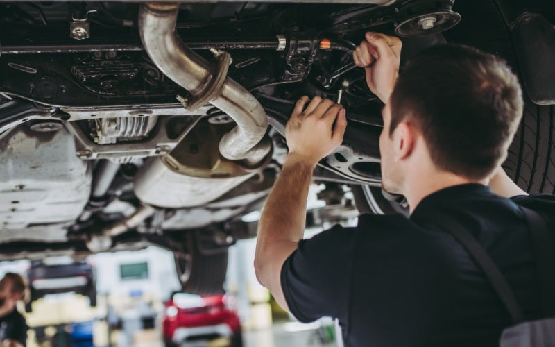 Image of technician underneath the car working on the vehicle